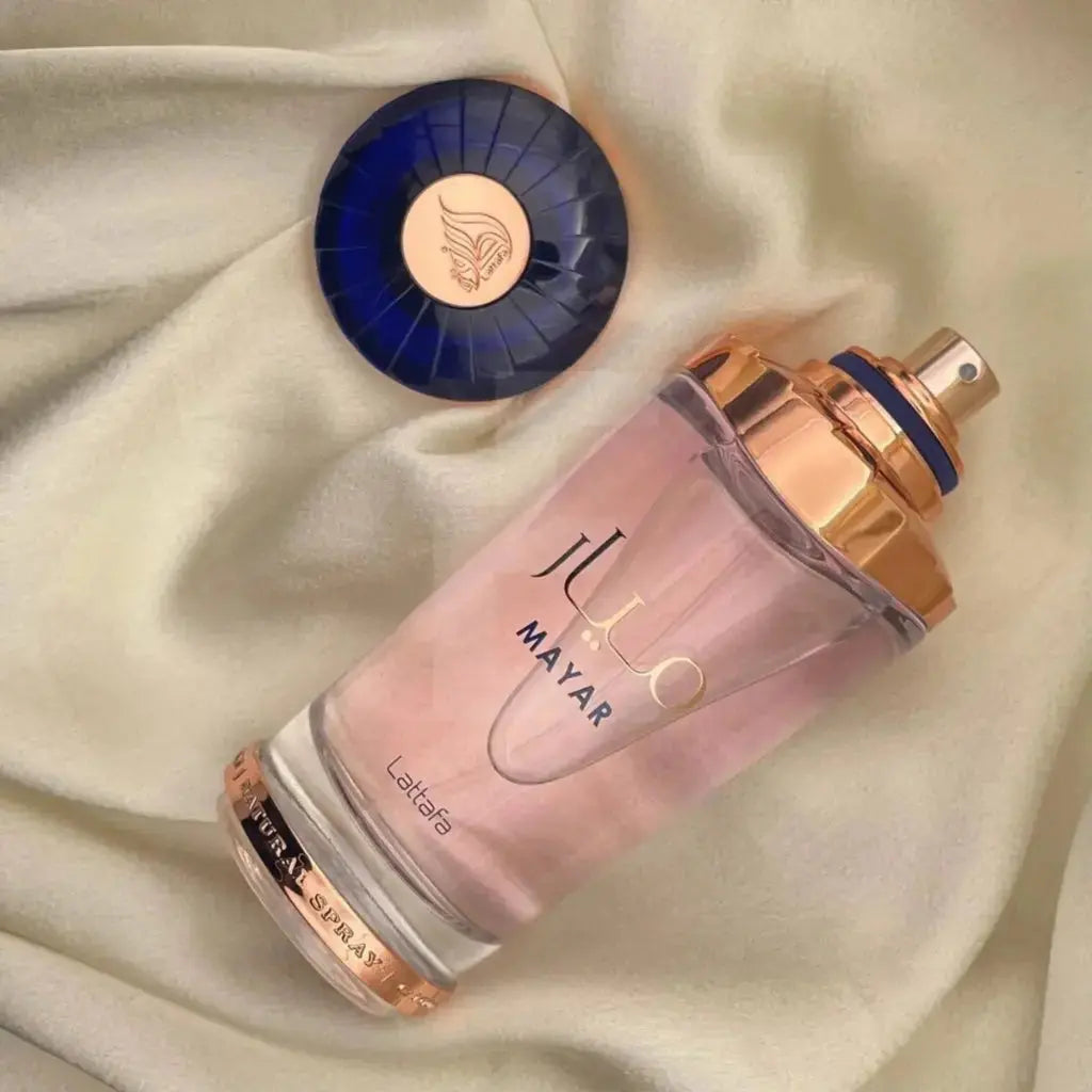 Lattafa Mayar damparfym i elegant glasflaska med rosa och guld detaljer på beige tyg