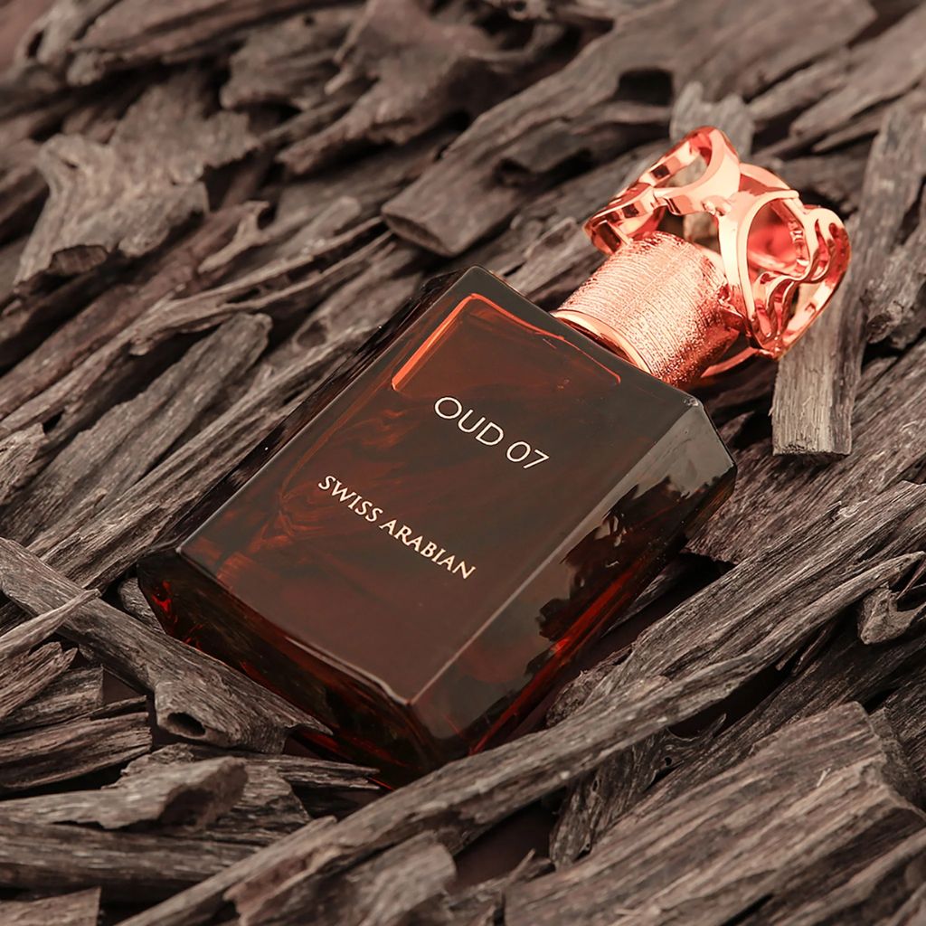 Swiss Arabian Oud 07 unisex parfymflaska med mörk brun design och gulddetaljer på träbakgrund