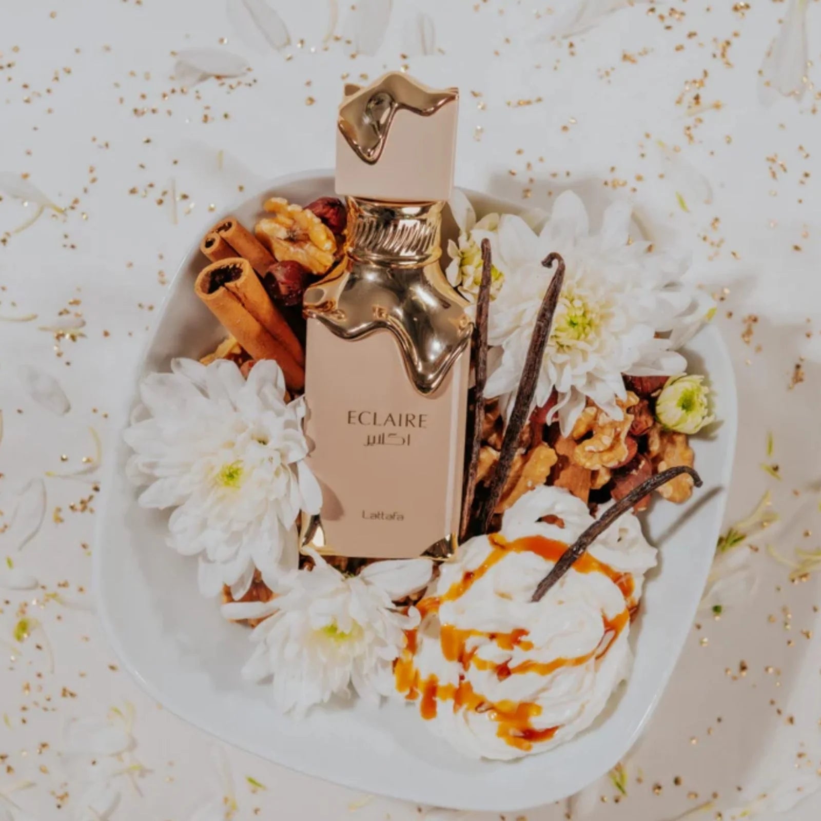 Damparfym Lattafa Eclaire i elegant flaska med blommor och kryddor som bakgrund